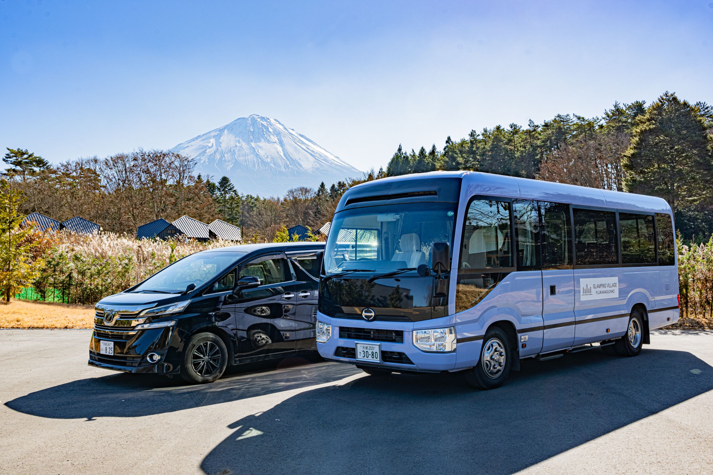 富士山を背に並ぶ送迎用のワゴン車とマイクロバス