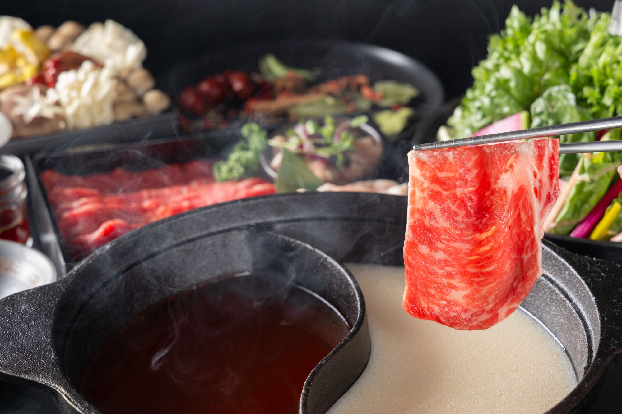 赤い火鍋のスープに牛肉をくぐらせる